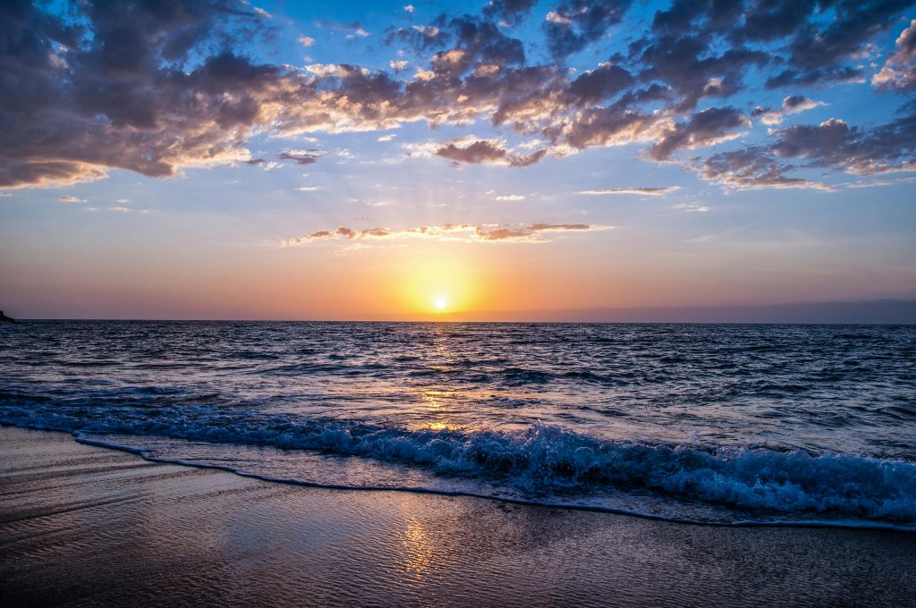 Strand, Meer, Himmel, untergehene, gold leuchtende Sonne, Wolken
Das Meer und der Himmel sind eher bläulich und die Wolken grau-weiß.