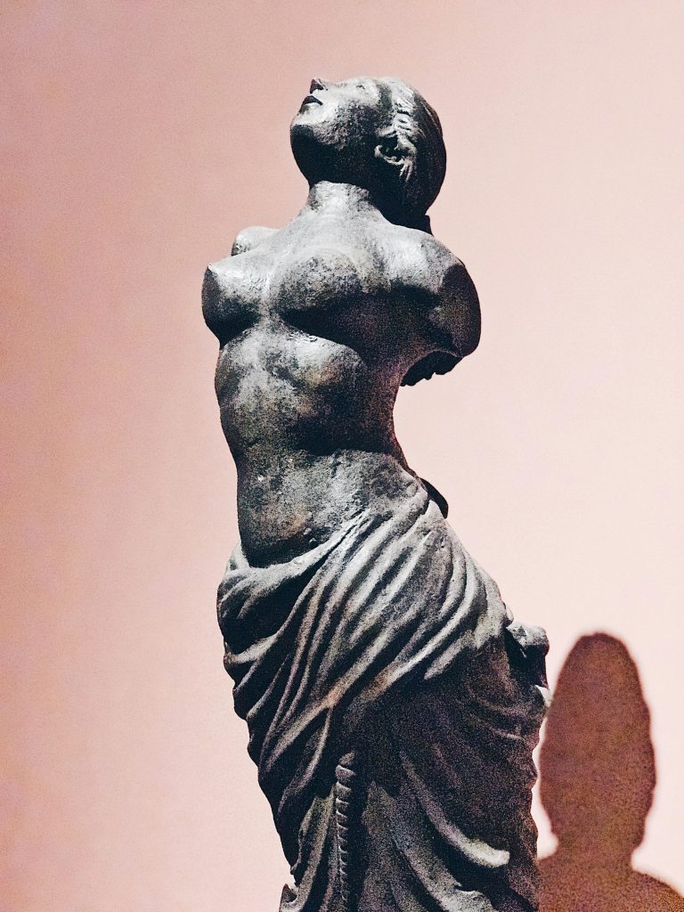 eine Statue von einer Frau mit rundlichen Formen, die um die Hüften ein Tuch gewickelt hat und oben nackt ist